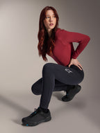 Alpinestars Stella A-Dura Thermal Pants, damskie spodnie MTB, czarne, prezentowane przez modelkę w kucającej pozie z bordową koszulką z długim rękawem i czarnymi butami rowerowymi, z białym logo gwiazdy na udzie, wytrzymała i ciepła konstrukcja do jazdy terenowej w zimnych warunkach