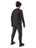 Alpinestars A-Dura Thermal Jersey, męska koszulka rowerowa z długim rękawem, czarna, widok z tyłu na modelu w czarnym kasku MTB, ciemnoszarych spodniach i czarnych rękawiczkach, profesjonalna odzież MTB na chłodne dni