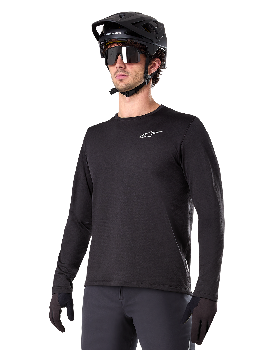 Alpinestars A-Dura Thermal Jersey, czarna koszulka MTB z długim rękawem, białe logo na piersi, noszona z czarnym kaskiem i rękawicami, nowoczesny sportowy design do jazdy na szlaku