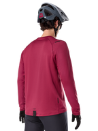 Alpinestars A-Dura Thermal Jersey, koszulka termiczna MTB z długim rękawem, bordowa, widok od tyłu na modelu w szarym kasku MTB i czarnych rękawiczkach, przedłużony tył i małe detale z logo, przeznaczona do jazdy w chłodne dni.