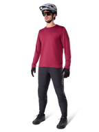 Alpinestars A-Dura Thermal Jersey w kolorze bordowym, ocieplana koszulka rowerowa z długim rękawem noszona z ciemnoszarymi spodniami MTB, czarnymi rękawiczkami i szarym kaskiem, ujęcie studyjne całej sylwetki odzieży rowerowej na zimne dni