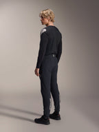 Alpinestars A-Aria Polartec Elite Jersey - Long Sleeve, czarna, prezentowana przez modela z profilu od tyłu, białe logo na ramieniu, w zestawie z pasującymi czarnymi spodniami rowerowymi, profesjonalny strój MTB