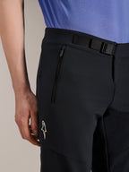 Alpinestars A-Aria Elite Shorts, Mountain Bike Shorts, Black Titanium, featuring a magnetic buckle closure, zippered pocket, and white Alpinestars logo, worn with a blue cycling jersey, performance mountain bike gear