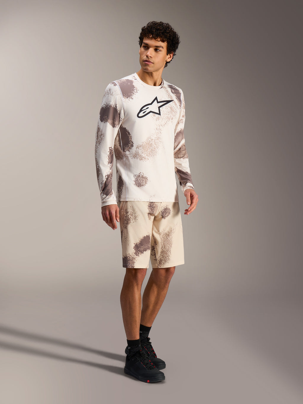 Koszulka MTB A-Dura Ride LS Sand Camo, duże logo na piersi, dopasowane szorty z wzorem kamuflażu.