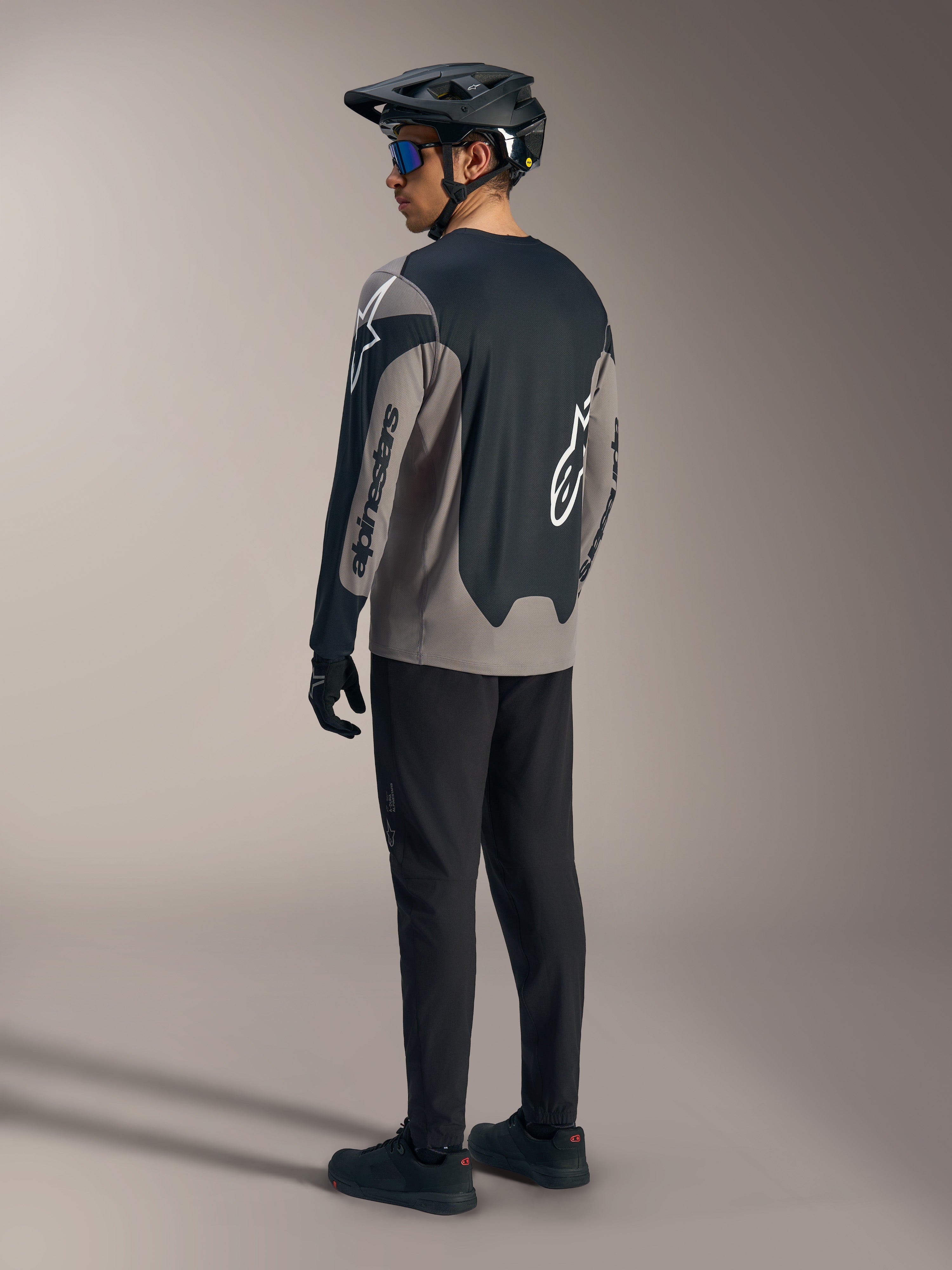 Szaro-czarna koszulka A-Dura Race LS z logo Alpinestars, widok z tyłu w pełnym zestawie MTB.