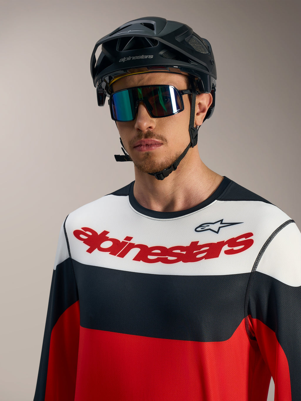 Koszulka A-Dura Race LS, czerwono-czarno-biała z logo na piersi, czarny kask MTB i gogle rowerowe.