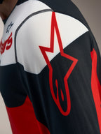 Detal czerwono-czarnej koszulki A-Dura Race z logo Alpinestars na oddychającej siateczce jacquard.