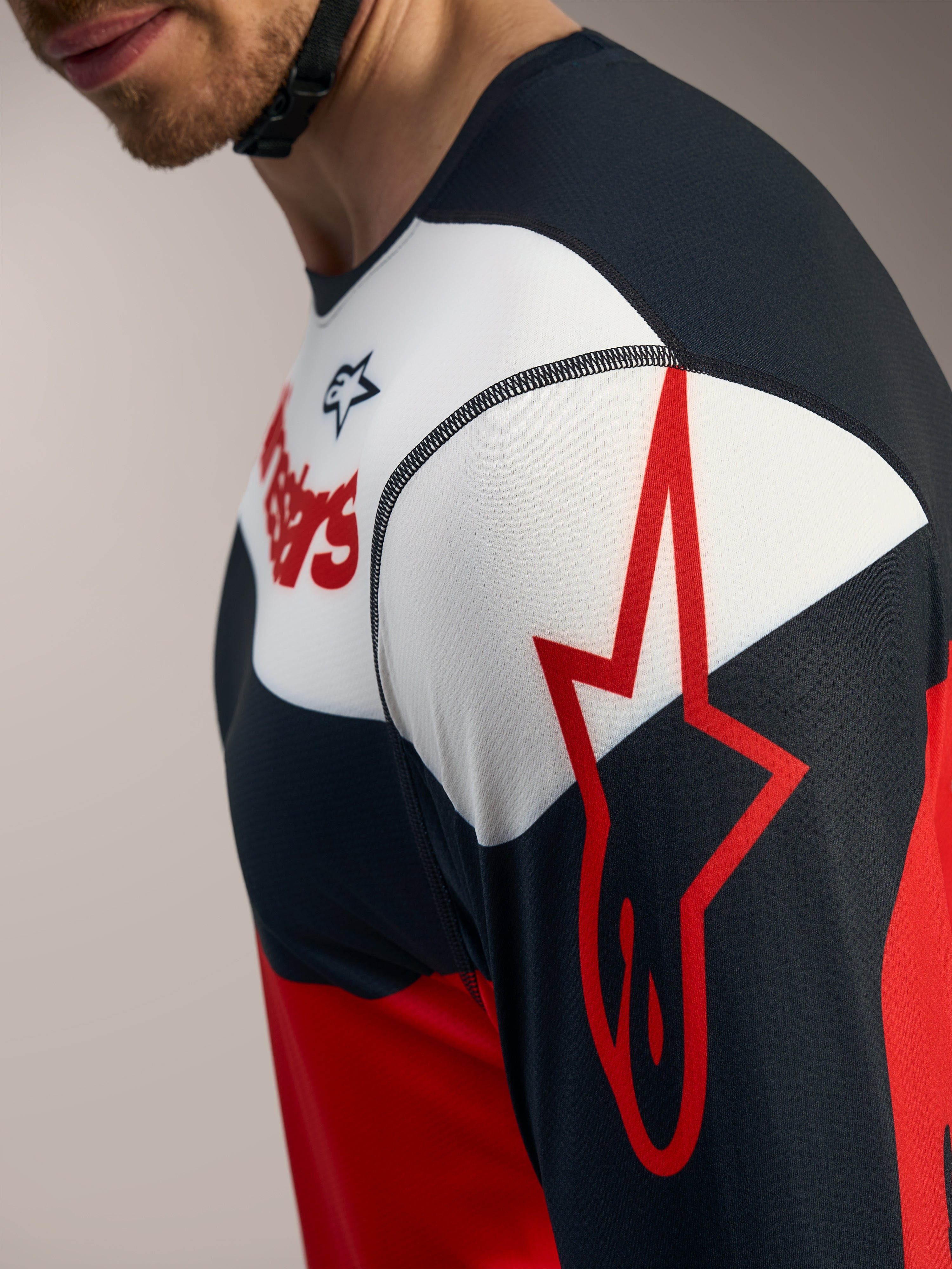 Koszulka A-Dura Race LS, detale w kolorze czerwonym, czarnym i białym z logo Alpinestars na rękawie.