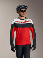 Koszulka A-Dura Race LS, czerwono-czarno-biała z logo Alpinestars, wyczynowy strój MTB z kaskiem i rękawicami.