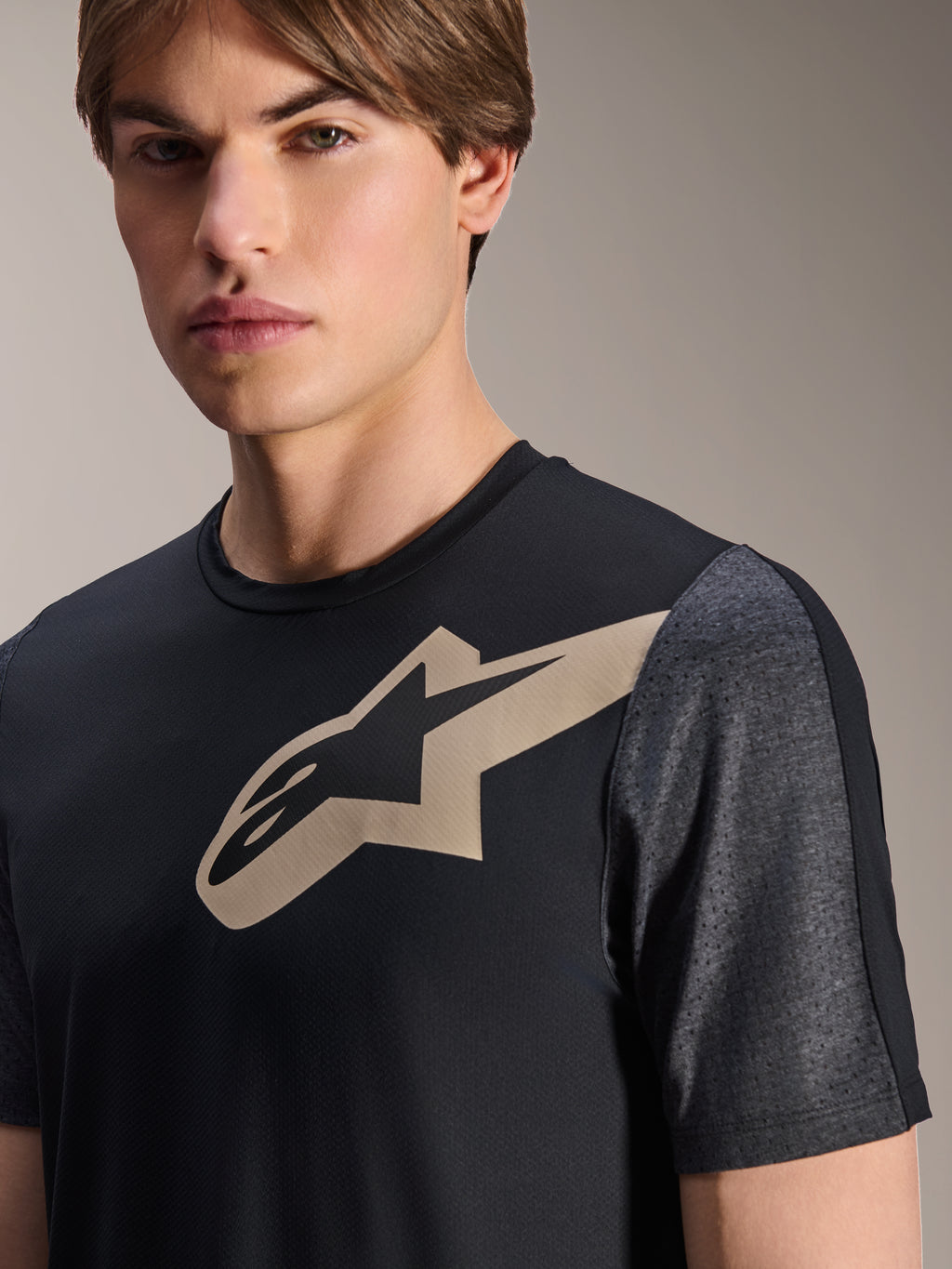 Koszulka Alpinestars A-Dura Lipan z krótkim rękawem, czarna, z beżowym logo Astars na piersi i ciemnoszarymi, melanżowymi, perforowanymi rękawami, wyczynowa odzież na rower górski