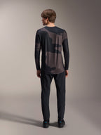 Alpinestars A-Dura Hollow Camo Long Sleeve Jersey, kolor Black Camo, widok z tyłu w czarnych spodniach, ciemny wzór kamuflażu i przedłużony tył dla lepszej osłony MTB.