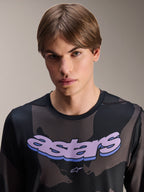 Alpinestars A-Dura Hollow Camo Jersey - Long Sleeve, koszulka z długim rękawem, czarny kamuflaż z fioletową grafiką „astars” na klatce piersiowej, zdjęcie studyjne męskiego modela, casualowy i techniczny styl MTB