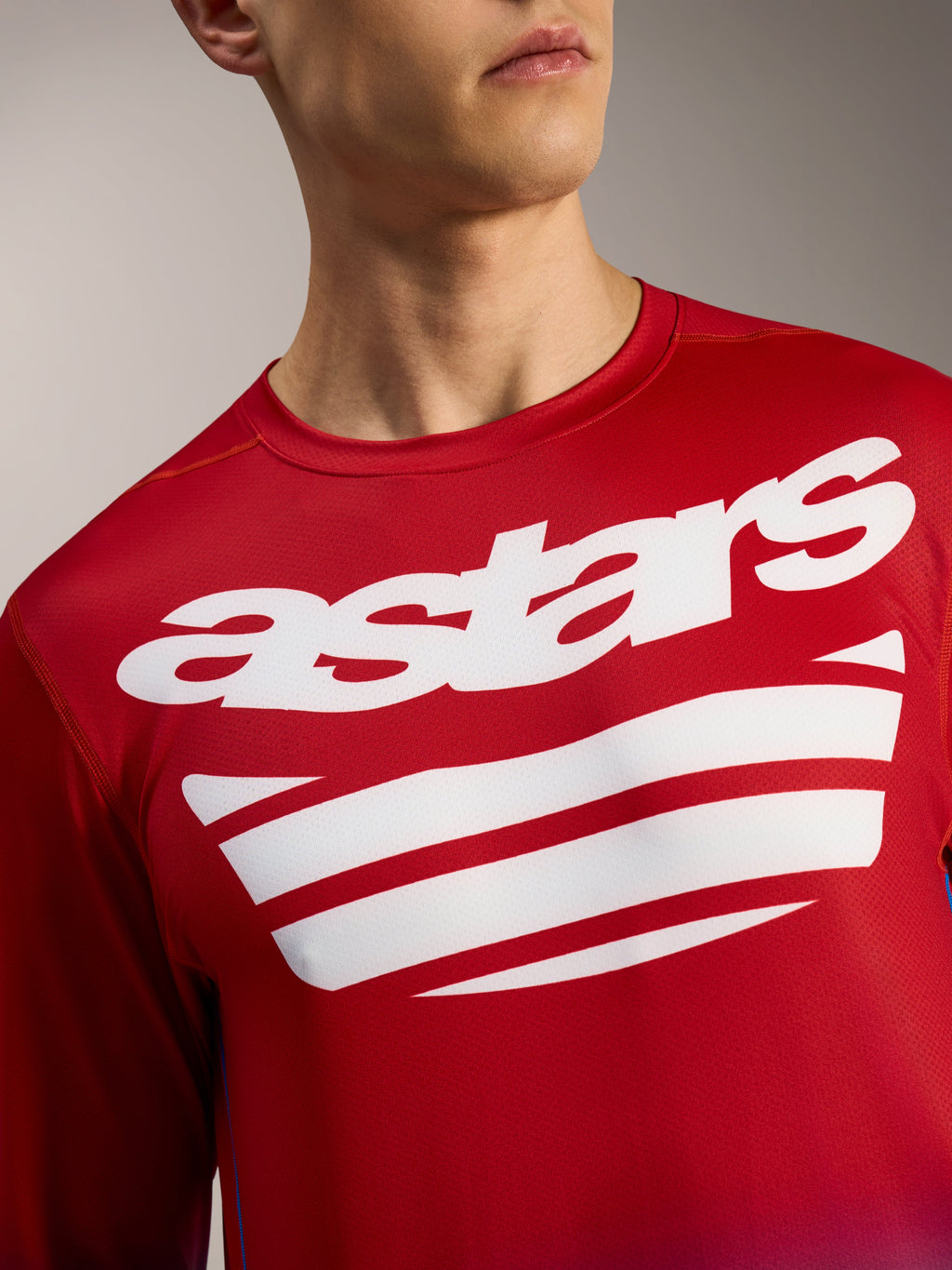 Koszulka MTB Alpinestars A-Dura ASTARS 2.0, jasnoczerwona z długim rękawem, biały napis i grafika w paski na piersi.
