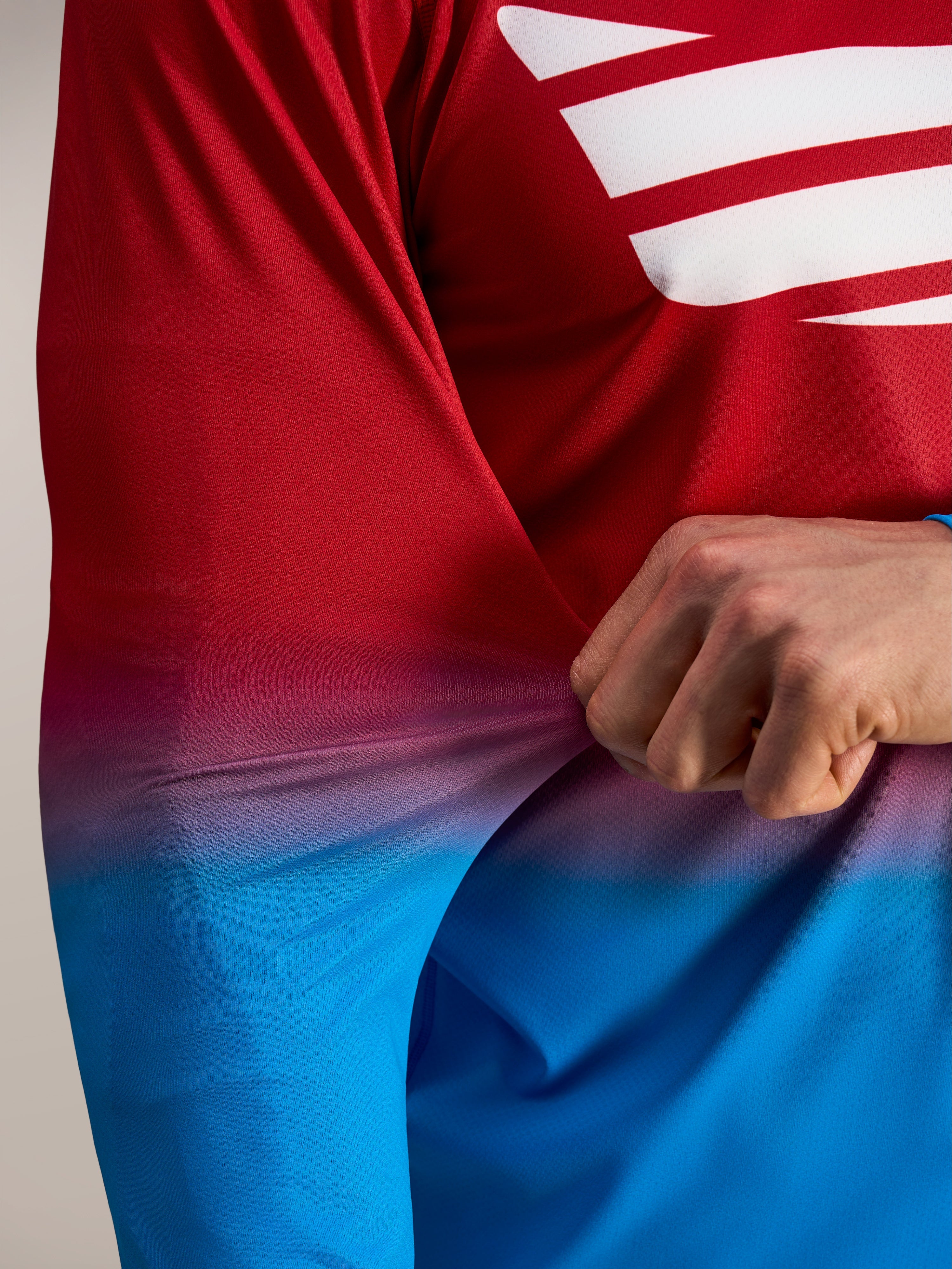 Elastyczny czerwono-niebieski materiał poli-spandex koszulki Alpinestars A-Dura ASTARS 2.0 z długim rękawem.