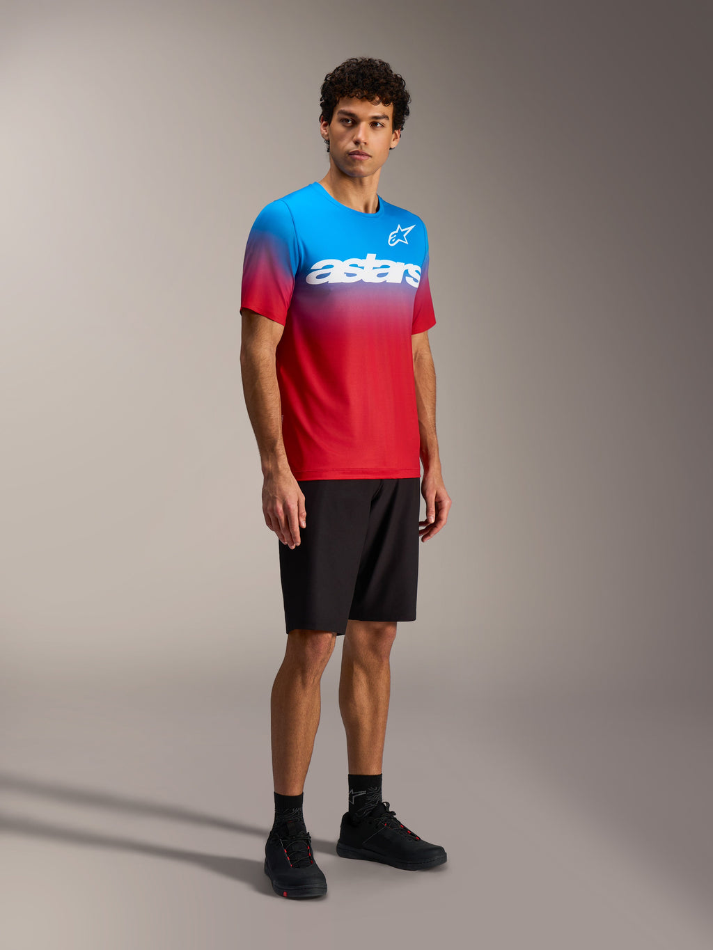 Koszulka MTB Alpinestars A-Dura ASTARS 2.0, czerwono-niebieski gradient, krótki rękaw, biały napis na piersi.