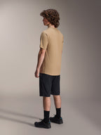 Alpinestars A-Dura Liner Shorts w kolorze czarnym i koszulka A-Dura SS w kolorze beżowym, noszone przez modela widocznego z profilu, w zestawieniu z czarnymi skarpetami i butami rowerowymi, lifestylowa odzież MTB.