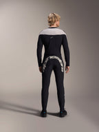Alpinestars A-Supra Melt Pants, czarne, widok z tyłu pokazujący duży biały napis Alpinestars na tylnym karczku, zestawione z pasującą koszulką z długim rękawem i czarnymi butami rowerowymi, wysokiej jakości odzież MTB do jazdy w terenie