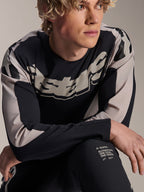 Koszulka Alpinestars A-Supra Melt, koszulka MTB z długim rękawem, czarna z jasnoszarymi grafikami, prezentowana przez modela, z wyraźnym logo na klatce piersiowej i napisem „One Goal. One Vision.”, profesjonalna odzież do kolarstwa górskiego