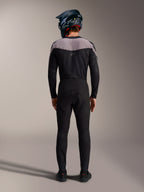 Czarny zestaw MTB Alpinestars A-Supra Elite, techniczne spodnie i bluza z kaskiem full-face, widok z tyłu.