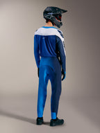 Strój MTB Alpinestars A-Supra Elite Faded Bright Blue, koszulka i spodnie widoczne z tyłu, kask full-face.