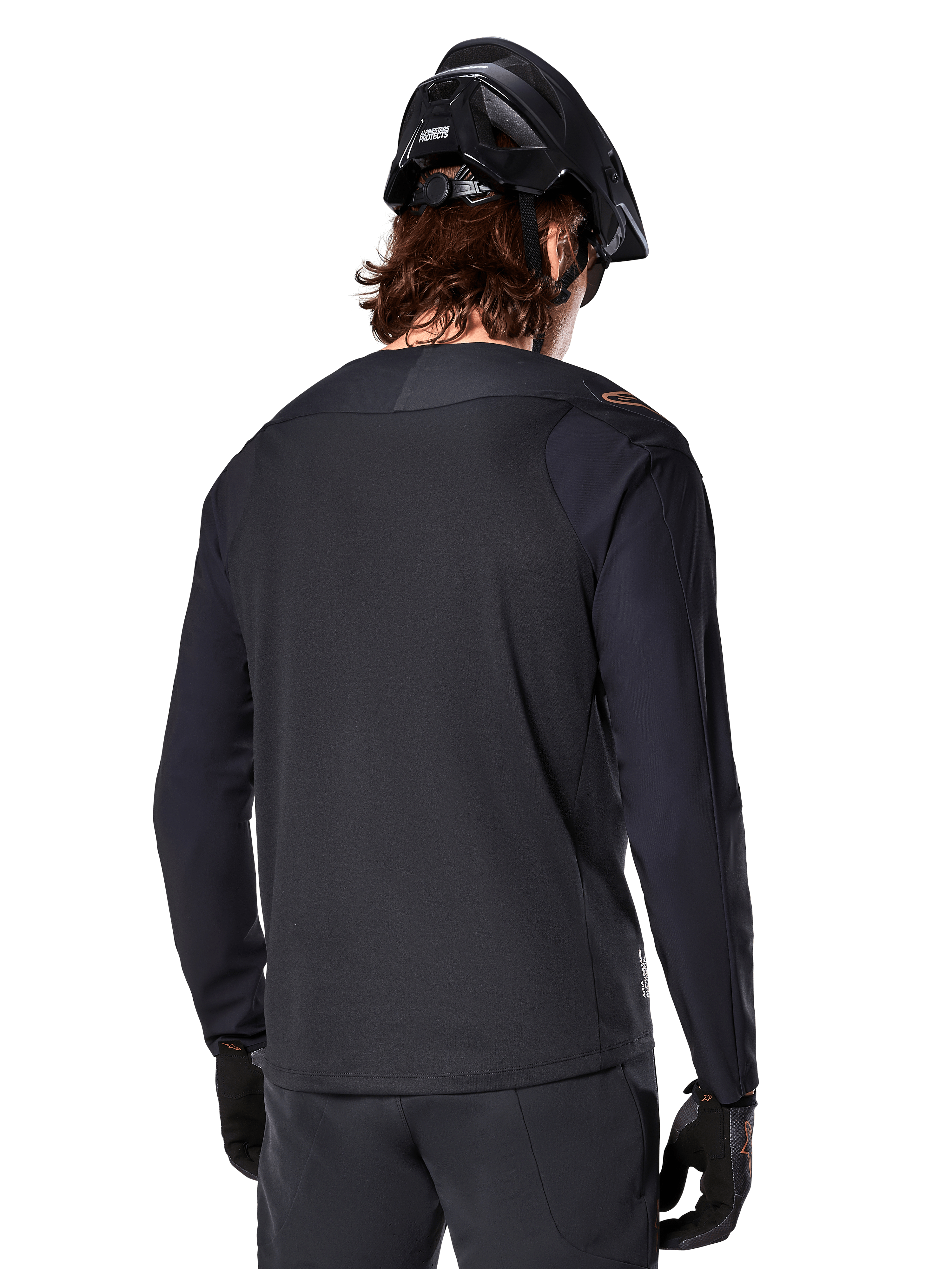 Alpinestars A-Aria Polartec Switch Jersey - Long Sleeve, czarna, widok z tyłu, noszona z czarnym kaskiem MTB i rękawicami, z przedłużonym tyłem zaprojektowanym dla lepszej wydajności w terenie