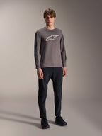 Alpinestars A-Dura Insert Astar Jersey, koszulka MTB z długim rękawem, ciemnoszara, z dużym białym logo na klatce piersiowej, zestawiona z czarnymi spodniami technicznymi i czarnymi butami, odzież do jazdy terenowej
