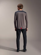 Alpinestars A-Dura Insert Astar Long Sleeve Jersey, ciemnoszara koszulka rowerowa z długim rękawem, widok od tyłu, grafitowe panele na ramionach i czerwona metka na dole, czarne spodnie i buty, odzież MTB