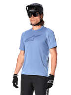 Alpinestars A-Dura Dri Astar Jersey Short Sleeve, Infinity Blue, koszulka na rower górski z wentylacją z siateczki na rękawach i dużym logo na piersi, noszona z czarnym kaskiem, okularami i rękawicami, techniczna odzież wyczynowa MTB