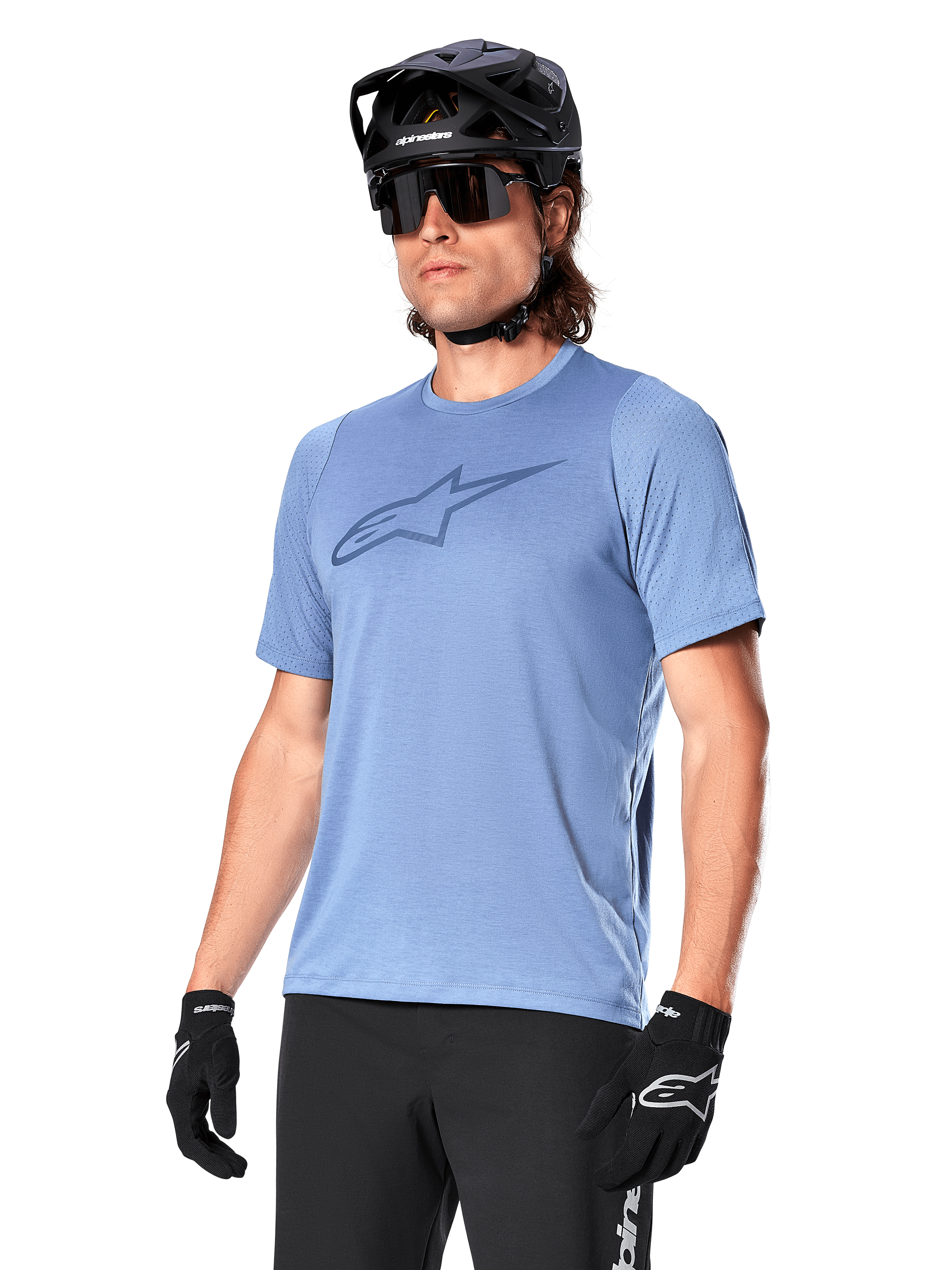 Alpinestars A-Dura Dri Astar Jersey Short Sleeve, Infinity Blue, koszulka na rower górski z wentylacją z siateczki na rękawach i dużym logo na piersi, noszona z czarnym kaskiem, okularami i rękawicami, techniczna odzież wyczynowa MTB