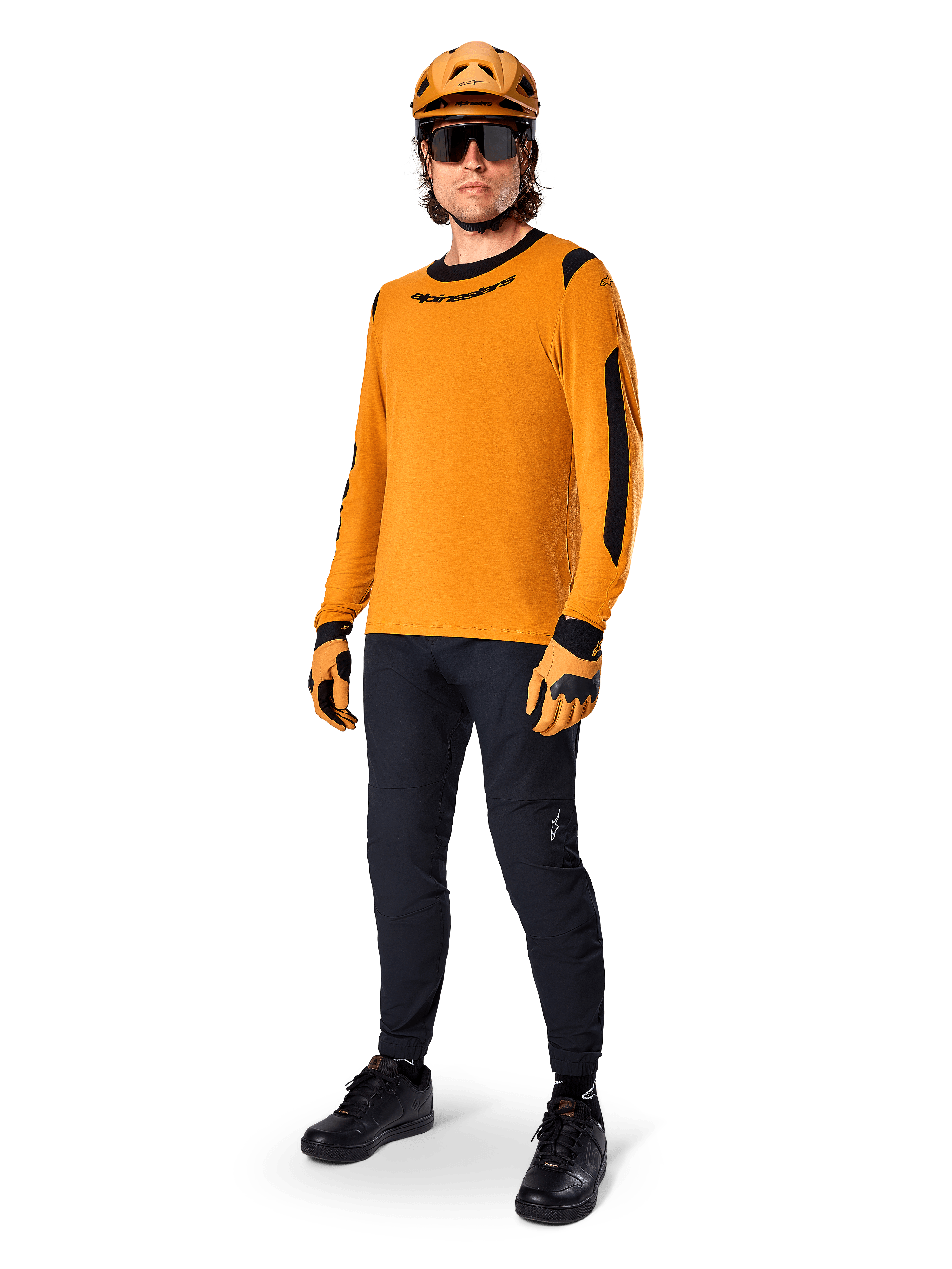 Alpinestars A-Dura Dri Wool Jersey - Long Sleeve, ciemnozłoty, noszony z dopasowanym pomarańczowym kaskiem, czarnymi spodniami MTB i żółto-czarnymi rękawicami, pełny strój rowerowy do jazdy terenowej