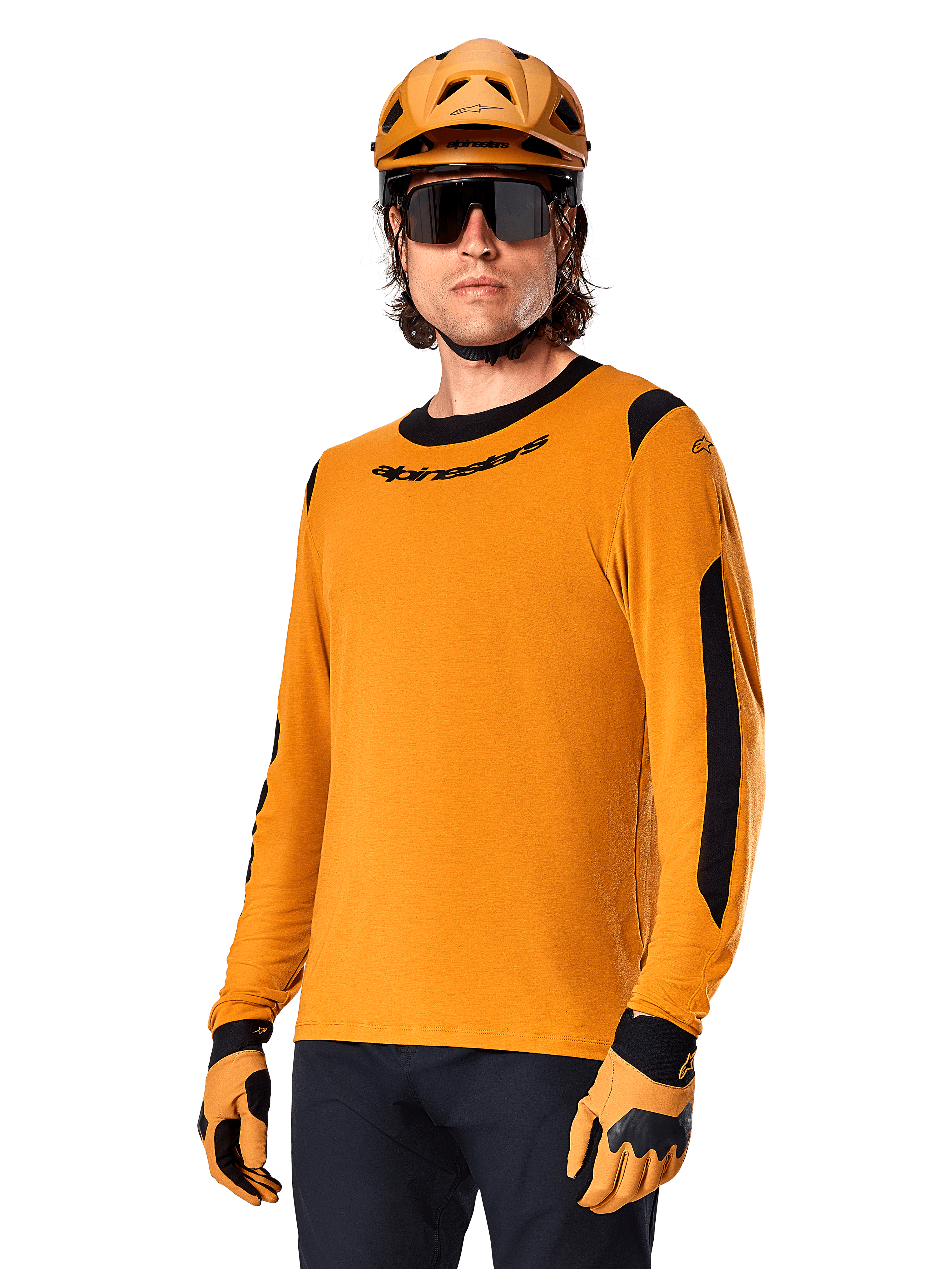 Alpinestars A-Dura Dri Wool Jersey z długim rękawem, koszulka rowerowa MTB, ciemnozłota i czarna, z odprowadzającej wilgoć mieszanki wełny merino i paneli siatkowych, rowerzysta w pasującym kasku, okularach przeciwsłonecznych i rękawicach