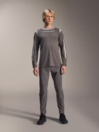 Alpinestars A-Dura Dri Wool Long Sleeve Jersey, ciemnoszara, model w pasujących szarych spodniach i czarnych butach, białe logo Alpinestars na piersi, jasnoszare panele z siatki na ramionach i rękawach, techniczna odzież na rower górski