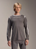 Alpinestars A-Dura Dri Wool Jersey Long Sleeve, ciemnoszara koszulka z długim rękawem noszona przez modela, jasnoszare panele z siateczki na ramionach i rękawach, białe logo na piersi, profesjonalna odzież rowerowa MTB