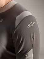 Alpinestars A-Dura Dri Wool Jersey - Long Sleeve, ciemnoszara, szczegółowy widok ramienia i rękawa z jasnoszarymi siateczkowymi panelami wentylacyjnymi i białym logo Astars na technicznej tkaninie drirelease.