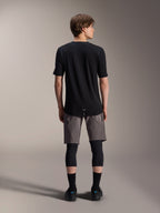 Alpinestars A-Dura Dri Wool Short Sleeve Jersey, Black, back view worn by model with grey MTB shorts and black knee guards, featuring a longer drop tail and athletic fit for off-road cycling