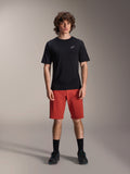 Alpinestars A-Dura Elite Shorts, spodenki rowerowe MTB, ciemnopomarańczowe, noszone z czarną koszulką z krótkim rękawem i butami rowerowymi, techniczna odzież do kolarstwa górskiego