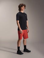 Męski model w spodenkach Alpinestars A-Dura Elite w kolorze Dark Orange i czarnej koszulce z krótkim rękawem A-Dura Dri Wool, odzież rowerowa MTB, czarne skarpety i buty, sportowy design do jazdy w terenie