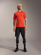 Koszulka z krótkim rękawem Alpinestars A-Aria Astar, Spicy Orange, noszona przez modela z czarnymi spodenkami MTB i ochraniaczami kolan, lekka i oddychająca odzież rowerowa do MTB