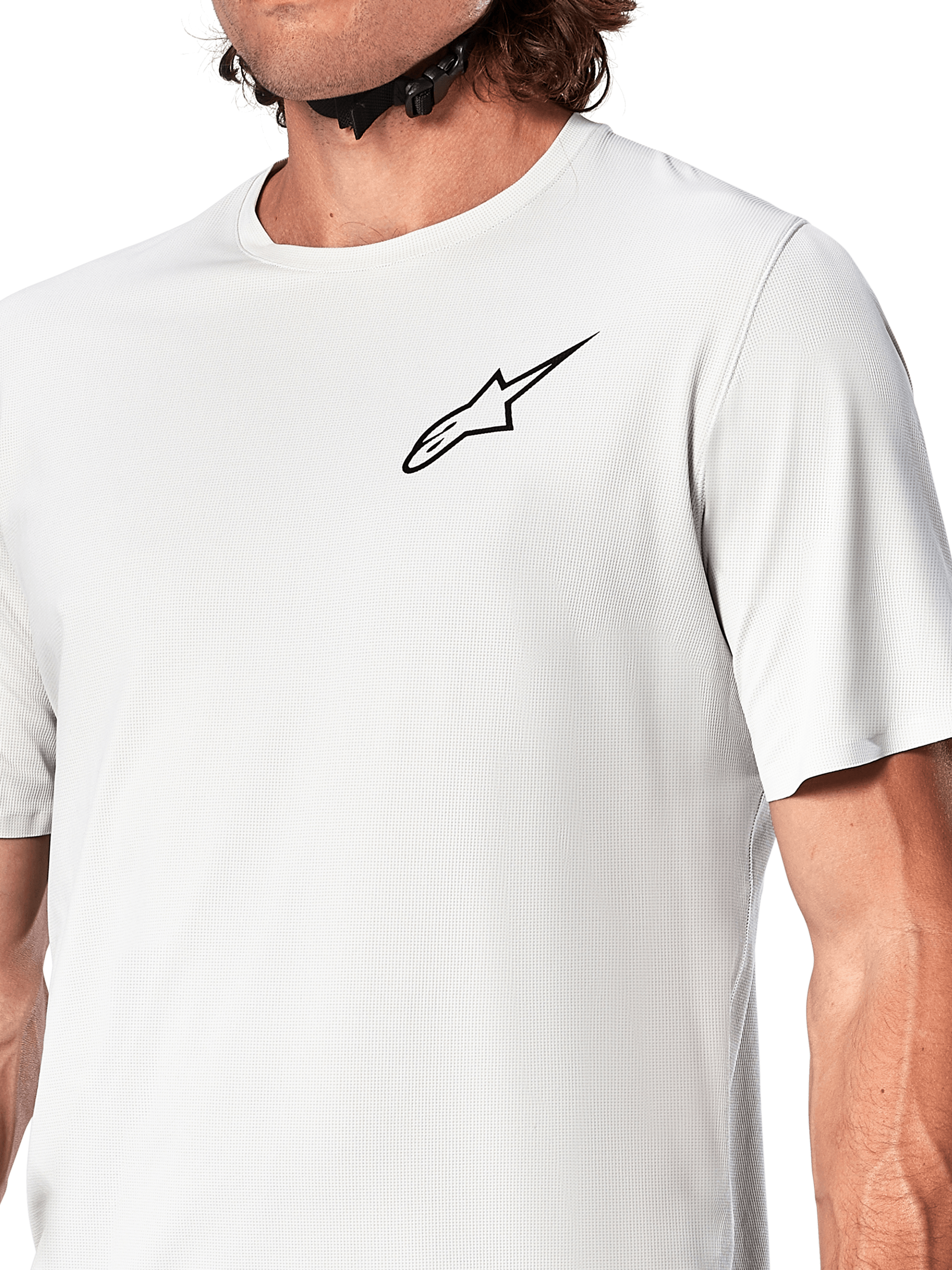 Alpinestars A-Aria Astar Jersey, koszulka rowerowa z krótkim rękawem, kolor White Dove, zbliżenie na czarne logo Astar na piersi, oddychający teksturowany materiał poliestrowy, lekki sportowy krój do jazdy MTB
