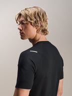 Mężczyzna w koszulce Alpinestars A-Aria Switch Jersey, krótki rękaw, czarna, widok z boku i z tyłu prezentujący sportowe dopasowanie i detale na ramieniu, lekka, oddychająca odzież rowerowa MTB