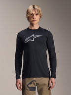 Alpinestars A-Dura Astar Long Sleeve Jersey, Black with silver Astars logo on the chest, worn by a model with camouflage pants, casual MTB performance apparel for mountain biking