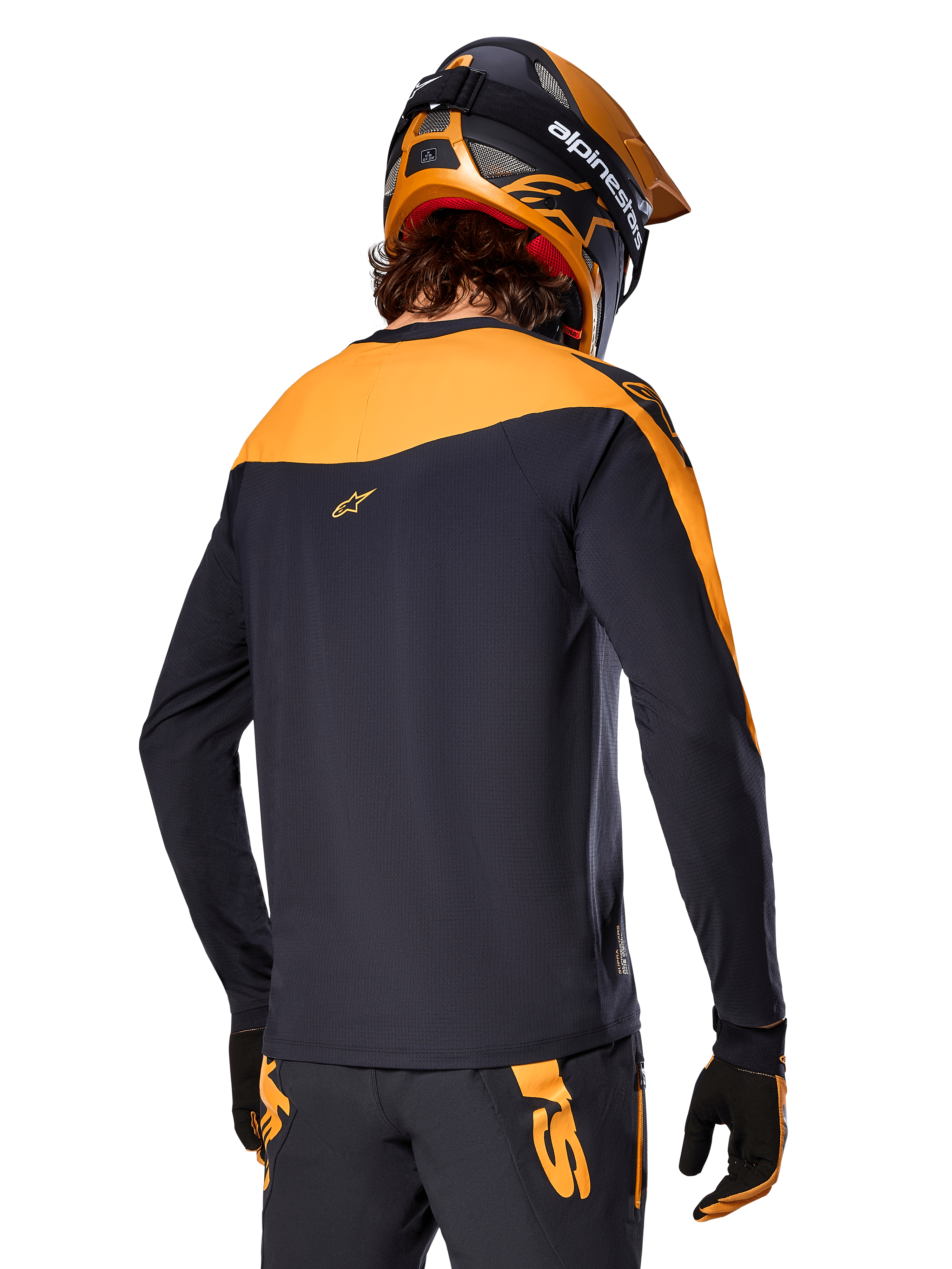 Alpinestars A-Supra Race Jersey - Long Sleeve, czarno-pomarańczowa, widok z tyłu na rowerzystę w pasującym kasku i spodniach MTB, sportowy krój z mikroperforowaną teksturą, profesjonalny strój wyścigowy MTB