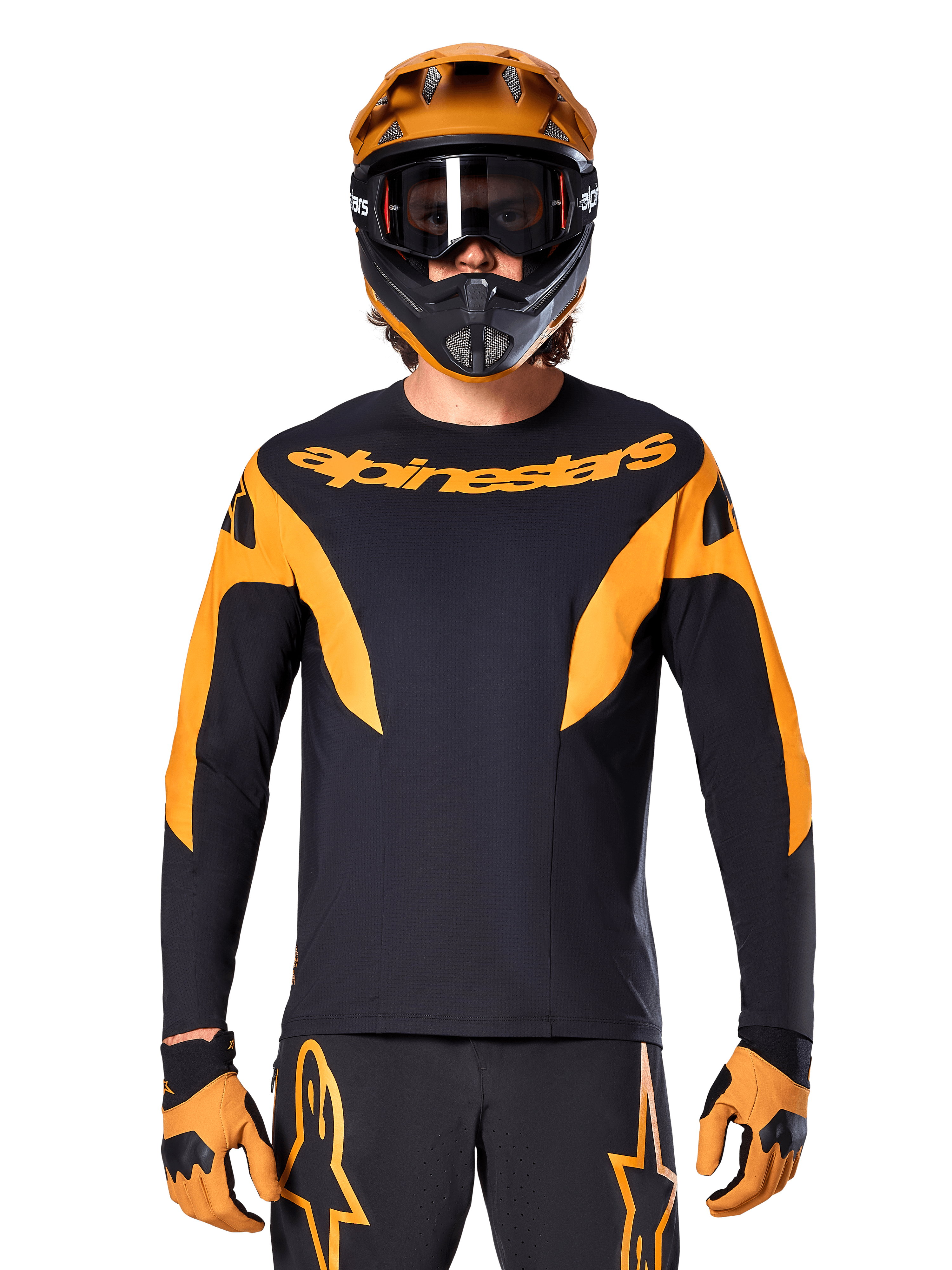 Rowerzysta MTB w koszulce Alpinestars A-Supra Race z długim rękawem, czarna z pomarańczową grafiką i logo na piersi, w zestawie z pomarańczowym kaskiem full-face, czarnymi goglami i pomarańczowymi rękawicami, profesjonalny strój do wyścigów górskich
