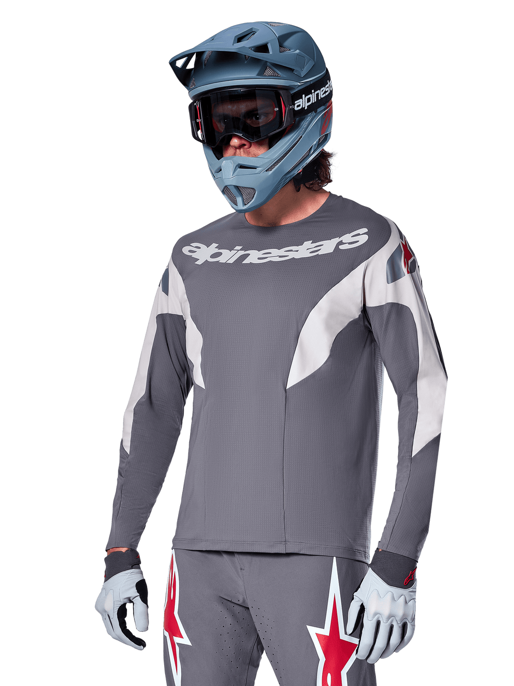 Alpinestars A-Supra Race Jersey - Long Sleeve, ciemnoszara koszulka z długim rękawem, białe i czerwone akcenty, grafika w stylu wyścigowym, noszona z pasującymi szarymi spodniami, niebieskim kaskiem full-face i białymi rękawicami, profesjonalny sprzęt do MTB i downhillu