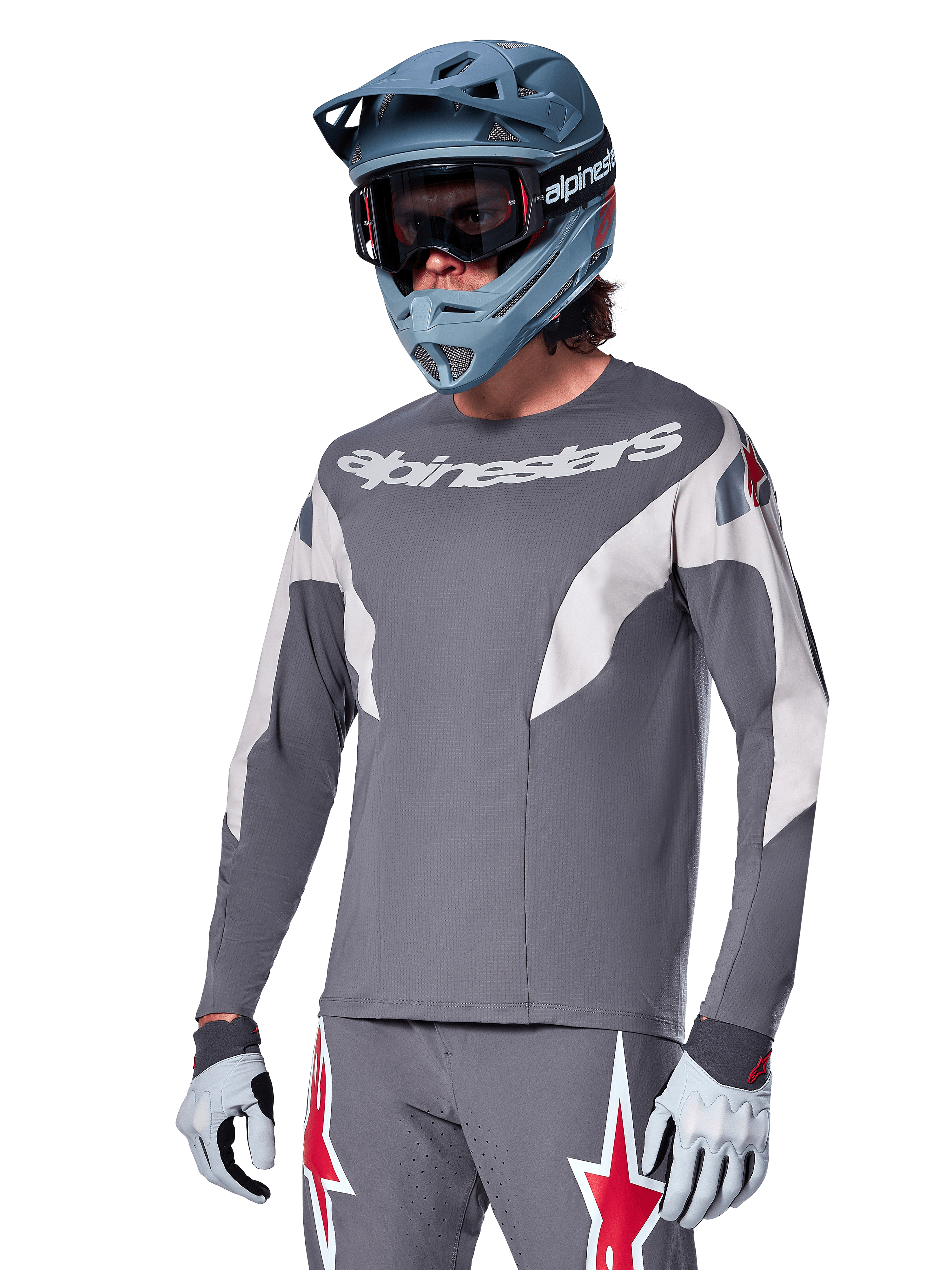 Alpinestars A-Supra Race Jersey - Long Sleeve, ciemnoszara koszulka z długim rękawem, białe i czerwone akcenty, grafika w stylu wyścigowym, noszona z pasującymi szarymi spodniami, niebieskim kaskiem full-face i białymi rękawicami, profesjonalny sprzęt do MTB i downhillu