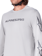 Alpinestars A-Dura Switch Jersey - Long Sleeve, jasnoszara koszulka rowerowa MTB z ciemnoszarym napisem na piersi i logo gwiazdy na rękawie, oddychająca żakardowa tekstura, wydajna odzież rowerowa do jazdy po szlakach