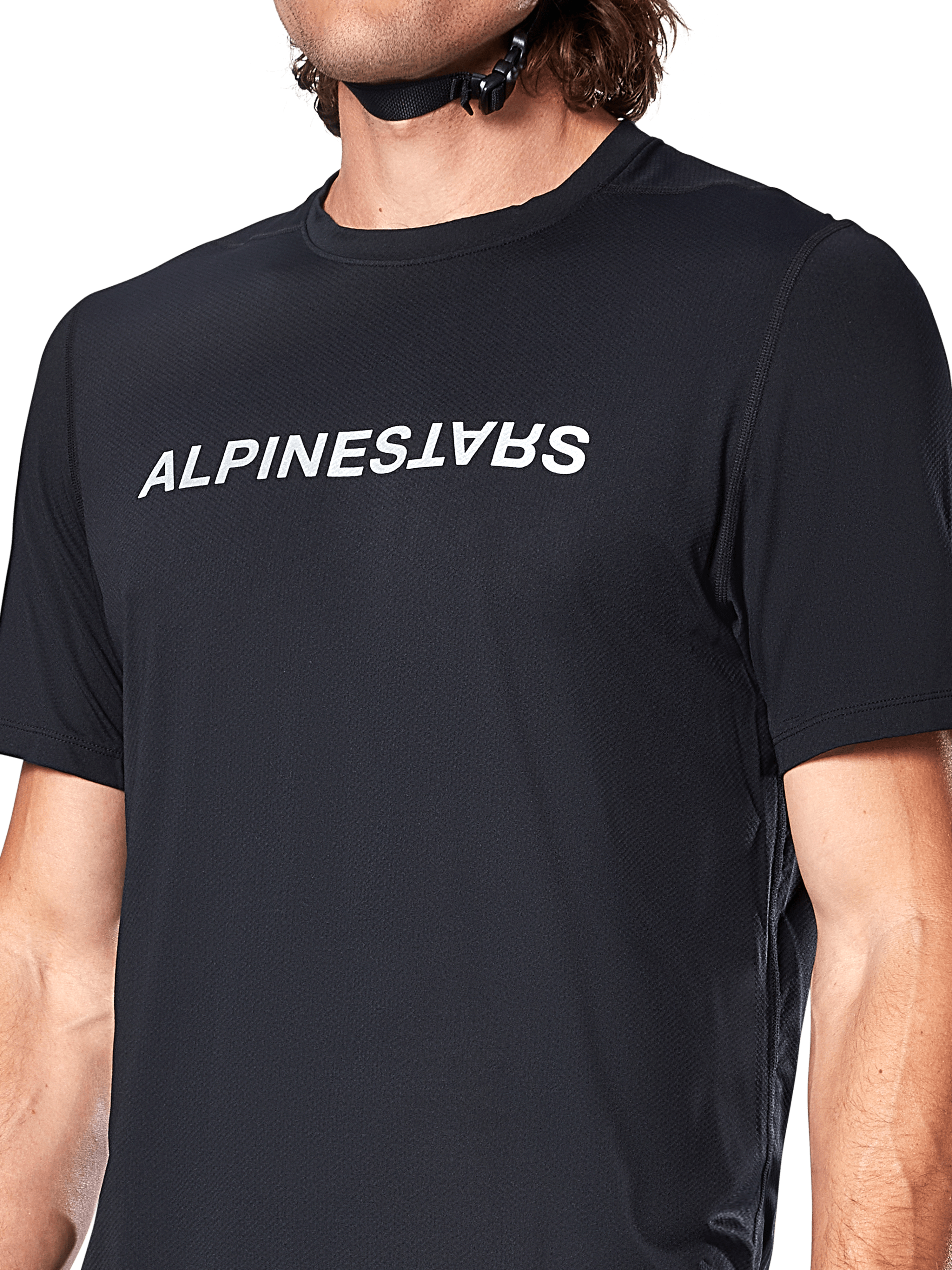 Alpinestars A-Dura Switch Short Sleeve Jersey, czarna koszulka z krótkim rękawem, duże białe logo nadrukowane na klatce piersiowej, tekstura materiału żakardowego, zbliżenie z przodu