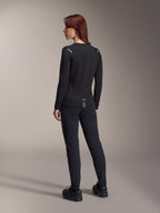 Alpinestars Stella A-Dura Thermal Jersey, damska koszulka MTB z długim rękawem w kolorze czarnym, widok z tyłu pokazujący odblaskowe akcenty na ramionach i przedłużony tył, noszona z czarnymi spodniami i butami, profesjonalna odzież do kolarstwa górskiego.