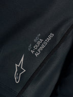 Czarna koszulka Stella A-Dura Ride, zbliżenie na techniczny żakard z logo Astars i napisem A-DURA ALPINESTARS.