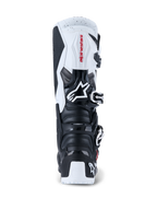 Alpinestars 2026 Tech 7 Enduro Boots, buty motocrossowe i enduro, czarno-białe, widok z tyłu prezentujący ochronne panele TPU na pięcie i łydce, czerwone logo Alpinestars na białym górnym panelu oraz srebrny system klamer, zaprojektowane do wyczynowej jazdy terenowej.